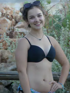 Brunette Posing by Fence in Aptera