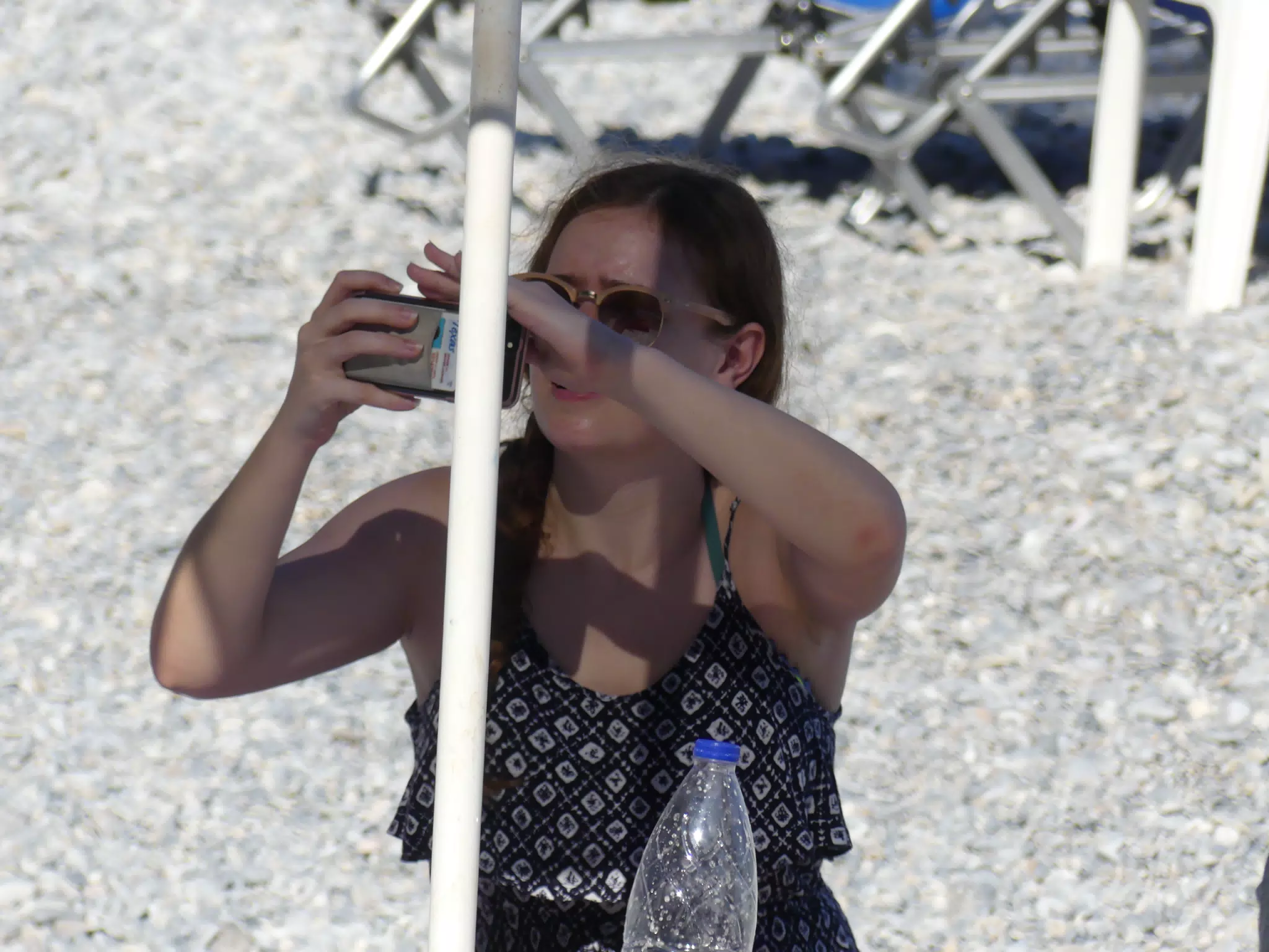 Girl on Beach Trying to See Phone