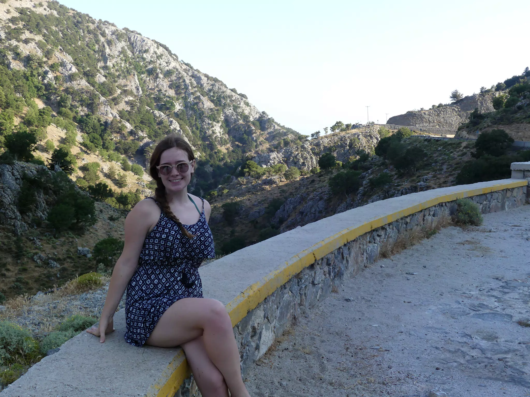 Madeline Sitting on Ledge of Canyon Overlook on Crete