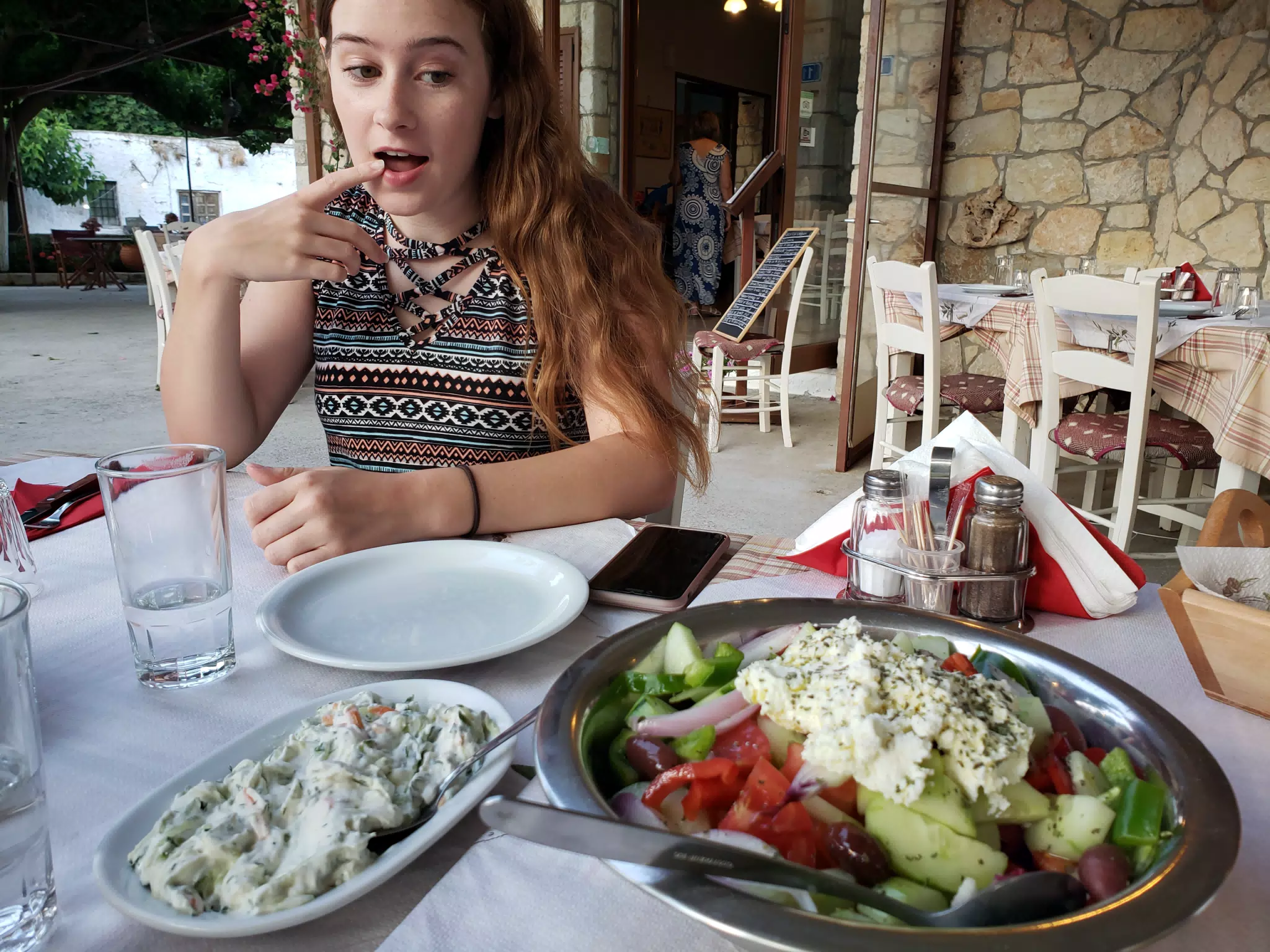 Madeline Eyeing All of the Food at the Cretan Corner