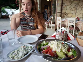 Madeline Eyeing All of the Food at the Cretan Corner