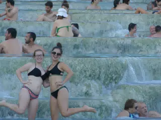 Sisters on One Foot in the Crowd at the Spa at Saturnia in Tuscany