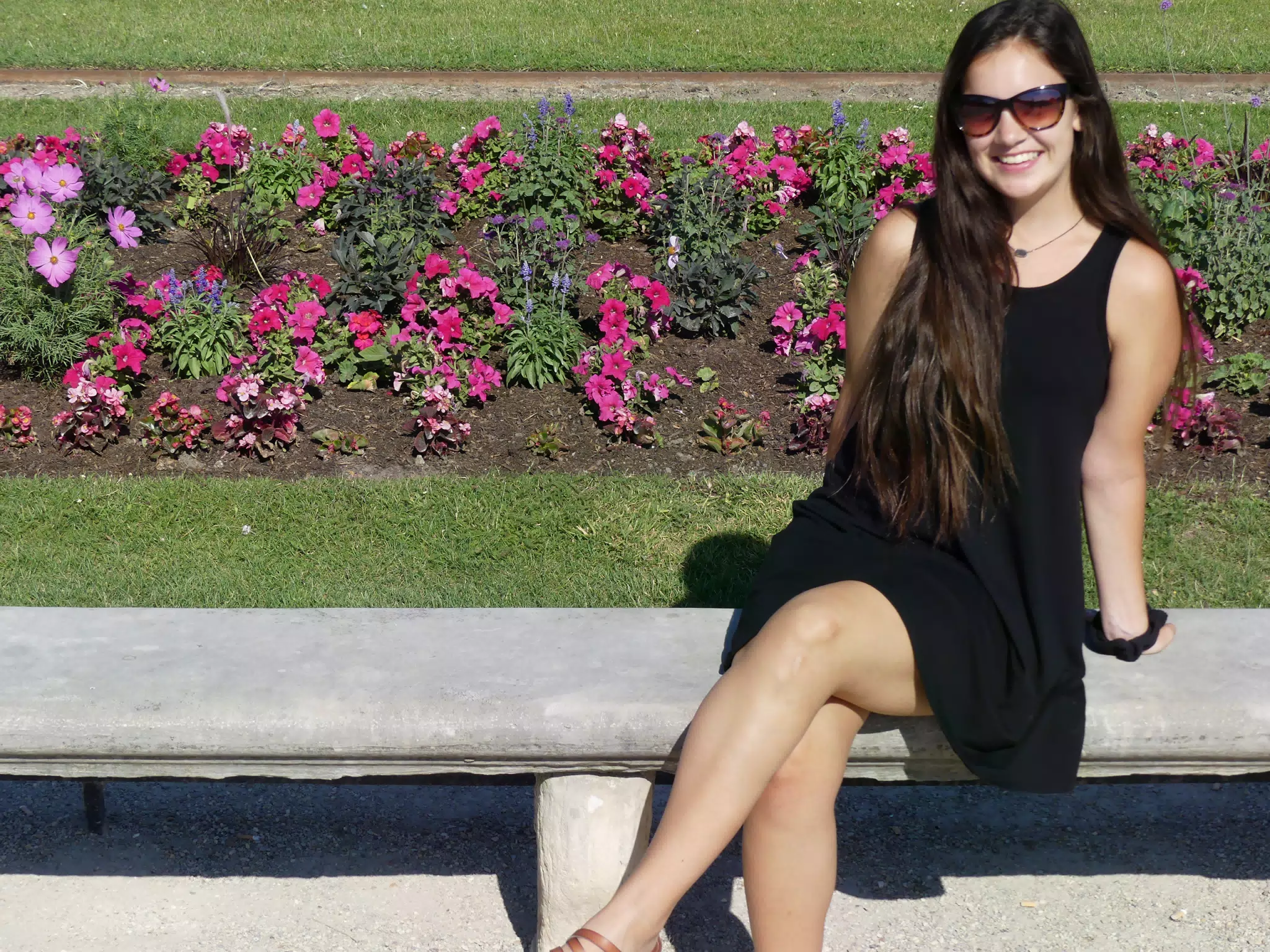 Emily in Black Dress on Park Bench by Flowers