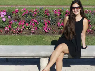 Emily in Black Dress on Park Bench by Flowers