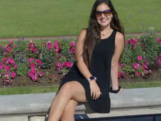 Emily in Black Dress on Park Bench with Flowers in Paris, France