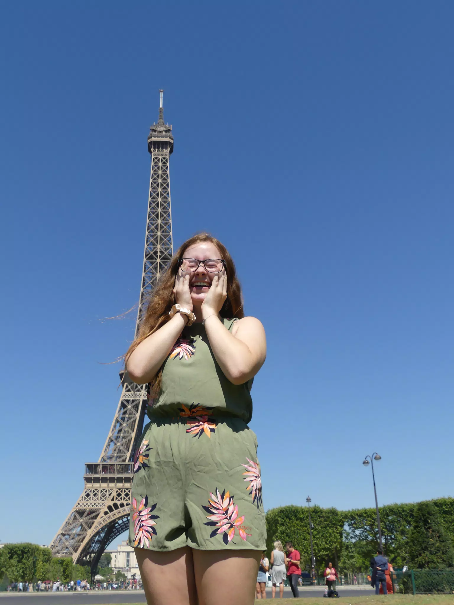 Girl Holding Face in Front of Eiffel Tower