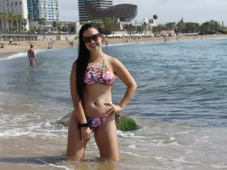 Teen Bikini Model on Knees in Mediterranean Sea on Beach in Barcelona Spain