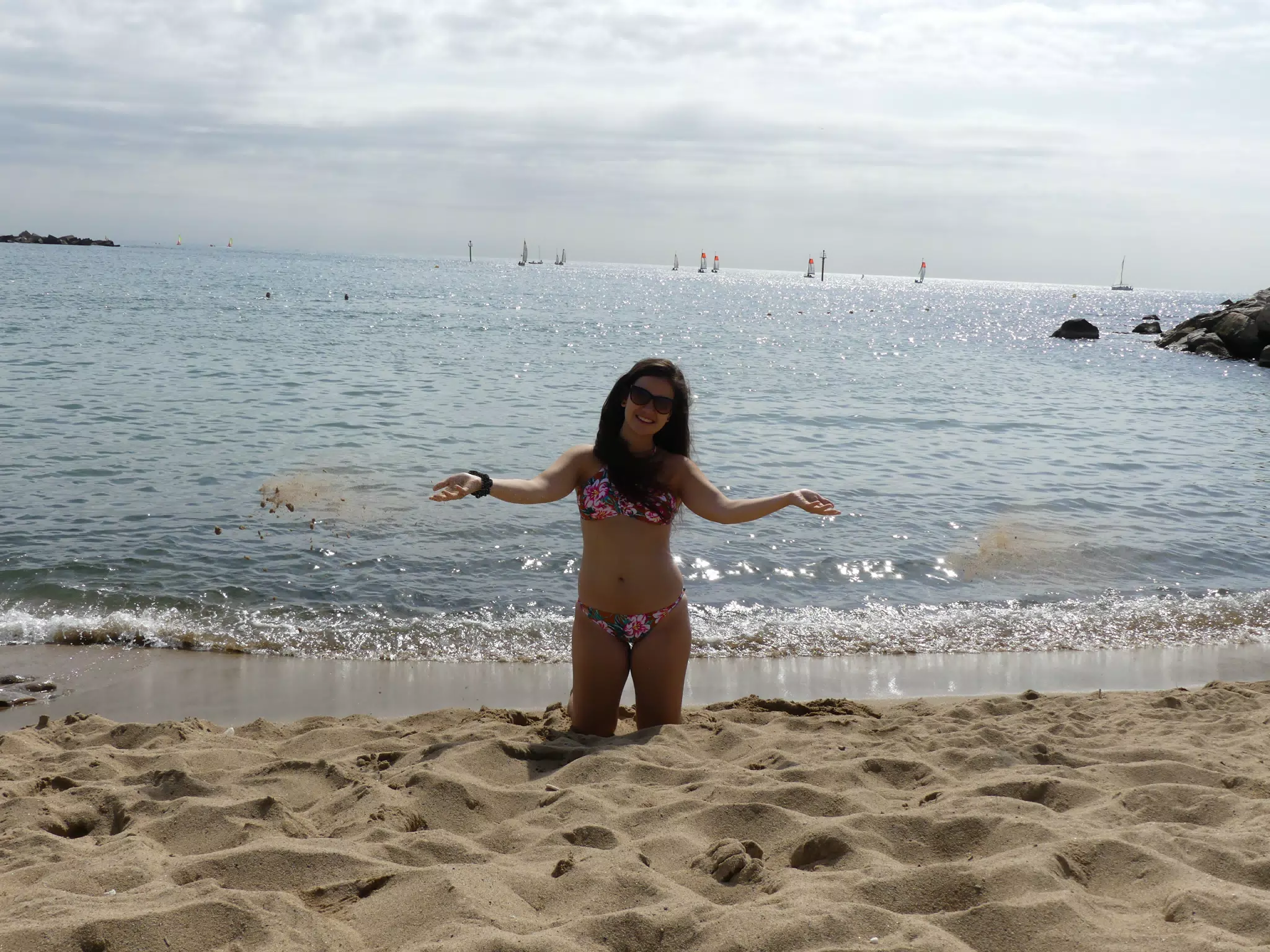 Teen Throwing Sand on Barcelona Beach in Bathing Suit
