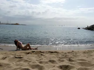 Girl Reclining on Barcelona Beach in Sunrise