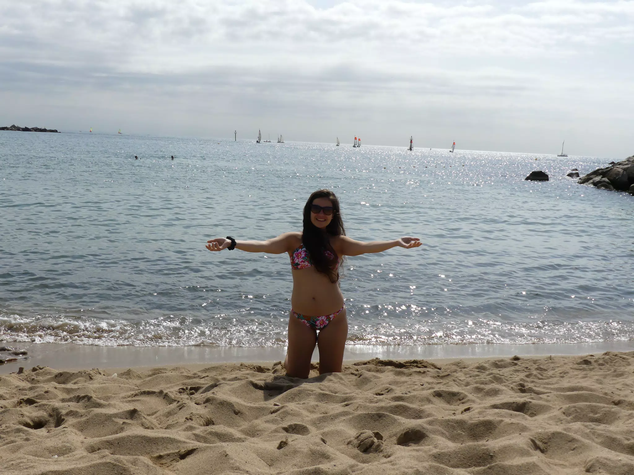 Teen Model with Outstretched Arms on Knees on Barcelona Beach