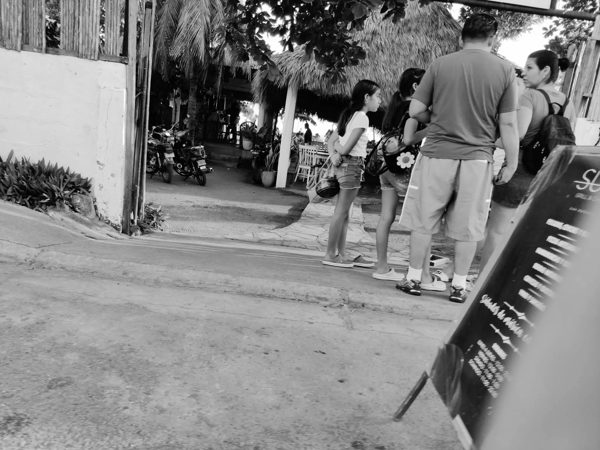 People on Street Considering Restaurant at the Beach
