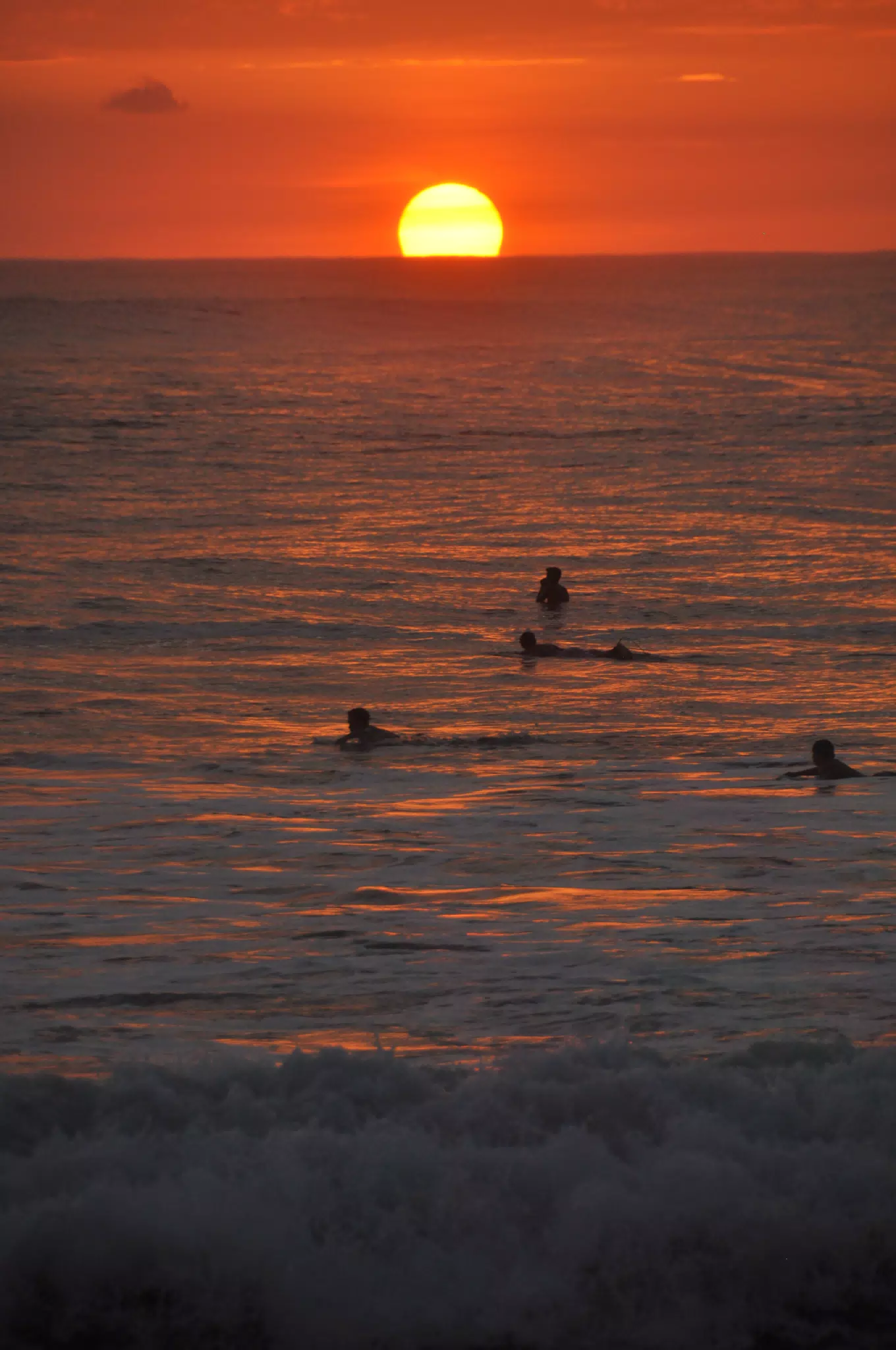 Swimmers in Reflection of Sunset on the Pacific Ocean