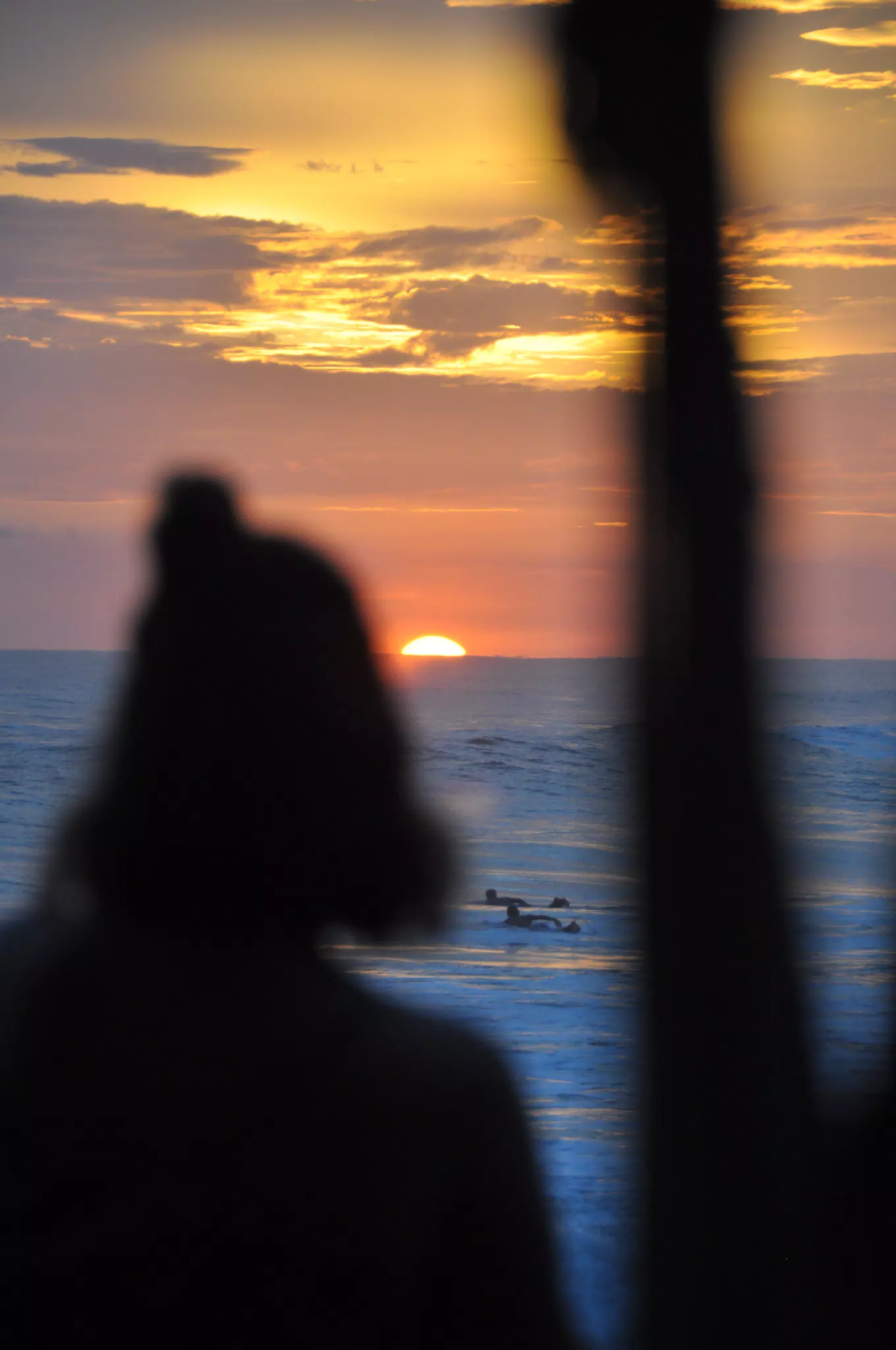 Girl Watching Sunset from Simple Beach Lodge