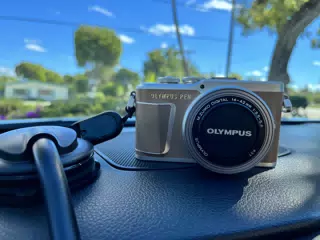 Olympus PEN E-PL9 & M.Zuiko 14-42mm Kit Lens on Car Dash in Mocha