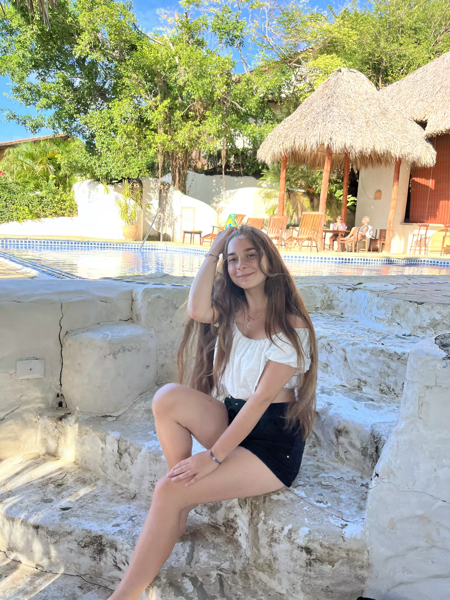Camille Sitting on the Poolside Steps at La Cascada at Pelican Eyes in San Juan del Sur, Nicaragua