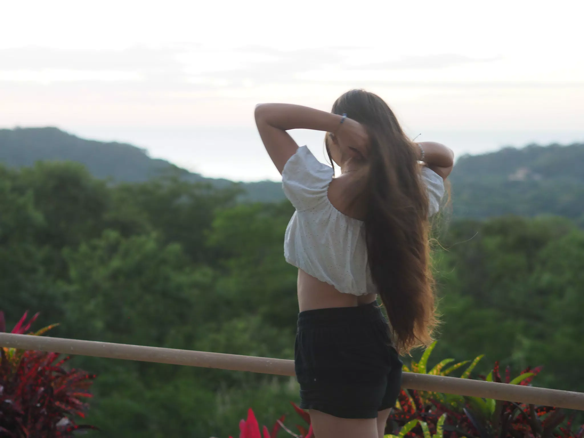 Teen Model Adjusting Hair by Pacific Ocean in San Juan del Sur, Nicaragua