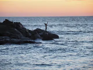 Sunset Reveler on the Rocks at The Simple Beach Lodge in Las Peñitas Nicaragua