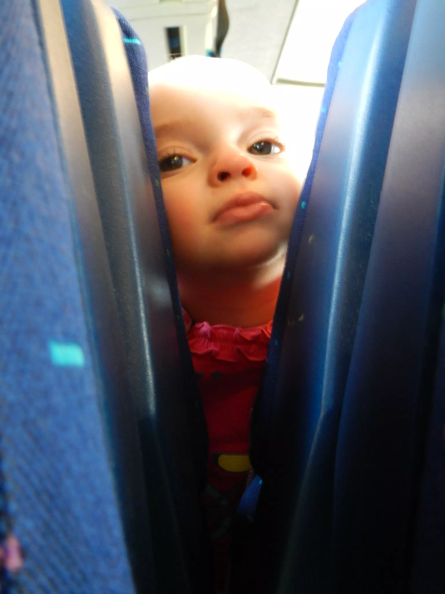 Luciana Peeking Between Train Seats